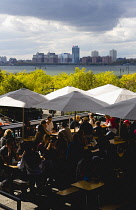 USA, New York, Manhattan, people seated at tables under umbrellas at an eating venue at the Chelsea Market Passage on the High Line linear park on a disused elevated railroad spur called the West Side...