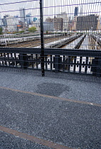 USA, New York, Manhattan, original rails in tarmac of the disused elevated West Side Line railroad making the High Line linear park overlooking the Hudson Rail Yards with trains at the north end in Mi...