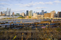 USA, New York, Manhattan, wild plant area and original rails of the disused elevated West Side Line railroad making the High Line linear park beside the Hudson Rail Yards with trains at the north end...