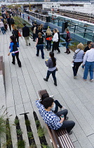 USA, New York, Manhattan, people walking among plants on the High Line linear park on an elevated disused railroad spur called The West Side Line beside the Hudson Rail Yards.