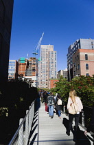 USA, New York, Manhattan, people walking on the Falcone Flyover on the High Line linear park between buildings on a disused elevated railroad spur of the West Side Line.