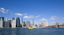 USA, New York, Lower Manhattan skyscraper skyline, suspension bridge and East River seen from Brooklyn Bridge Park.