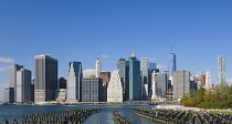 USA, New York, Lower Manhattan skyline skyscrapers seen from Brooklyn Bridge Park with wooden piles of Pier One in the East River.