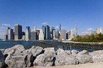 USA, New York, Lower Manhattan skyline skyscrapers seen from Brooklyn Bridge Park with wooden piles of Pier One in the East River.