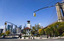 USA, New York, Brooklyn Bridge Park, Fulton Ferry Pier with The Brooklyn Ice Cream Factory below the suspension bridge beside Old Fulton Street with the skyscraper skyline of Lower Manhattan beyond.