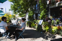 USA, New York, Brooklyn Bridge Park, People eating outdoors at 7 Old Fulton Restaurant on tables on the pavement of Old Fulton Street.