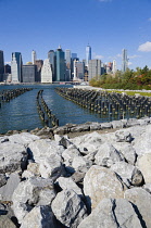 USA, New York, Lower Manhattan skyline skyscrapers seen from Brooklyn Bridge Park with wooden piles of Pier One in the East River.