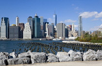 USA, New York, Lower Manhattan skyline skyscrapers seen from Brooklyn Bridge Park with wooden piles of Pier One in the East River.