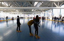 USA, New York, Rollerskaters on Brooklyn Bridge Park rollerskating rink on Pier 2.