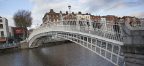 Ireland, Dublin, People crossing the Ha'penny Bridge across River Liffey viewed from the Temple Bar side.