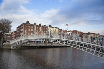 Ireland, Dublin, People crossing the Ha'penny Bridge across River Liffey viewed from the Temple Bar side.