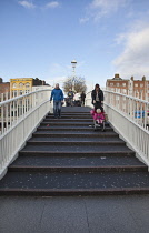 Ireland, Dublin, People crossing the Ha'penny Bridge across River Liffey viewed from the Temple Bar side.