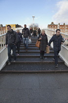 Ireland, Dublin, People crossing the Ha'penny Bridge across River Liffey viewed from the Temple Bar side.