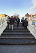 Ireland, Dublin, People crossing the Ha'penny Bridge across River Liffey viewed from the Temple Bar side.