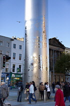 Ireland, Dublin, O'Connell Street, People standing at the base of the Spire sculpture.