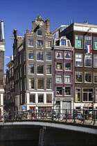 Netherlands, Noord Holland, Amsterdam, typical canal scene along the Herengracht with tall houses and bicycles by the railings.