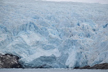 Norway, Svalbard, Nordenskild Glacier, Blue ice, Ice worn rock outcrop, Glacier front ready to calve ice into the fjord.