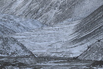 Norway, Svalbard, Longyearbyen glacier, Hikers walking up the lower section of the glacier, Moraine field in the foreground, Early Winter snow on valley sides.