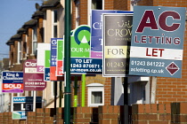England, West Sussex, Bognor Regis, a line of Estate Agents signs along a terrace of houses.
