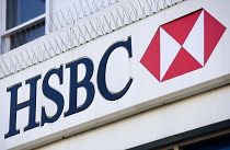 Business, Finance, Banking, HSBC sign on a high street bank building with metal pigeon control spikes above it.