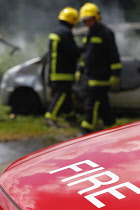 Essential Services, Firemen putting out fire in a car.