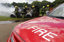 Essential Services, Firemen putting out fire in a car.