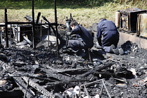 Essential Services, Fire, Forensic team examing charred ruin for potential causes of fire.