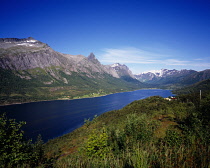 Norway, Nordland, Bjaerangfjorden, View east along fjord with the Oldratinden mountains on northern side with scattered houses amongst trees on lower slopes.