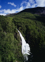 Norway, Hordaland, Naeroydalen, Stalheimfossen.  White waterfall crashing into steep sided valley gorge from area of dense forest.