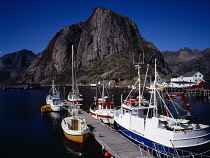 Norway, Lofoten, Moskenesoya Island, Hamnoy fishing village.  Moored fishing boats with Festhaeltinden Mountain behind.