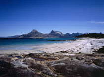 Norway, Nordland, Tysfjorden, View across fjord with mountains of the Breiskartinden Region in the background and stretch of sandy beach in the foreground.