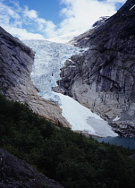 Norway, Sogn og Fjordane, Jostedalsbreen , Briksdalsbreen  one of several glacial tongues extending from the Jostedalsbreen glacier with meltwater lake and densely wooded area in foreground.