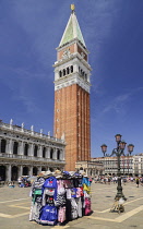 Italy, Venice, Piazzetta San Marco, Campanile di San Marco, St Mark's Campanile or bell tower with a souvenir clothing stand in the foreground