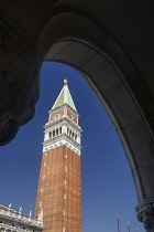 Italy, Venice, St Mark's Campanile or bell tower viewed from the arcade of the Doge's Palace in the Piazzetta di San Marco.