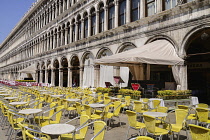 Italy, Venice, St Mark's Square, Colourful open air restaurant seating with awnings for musicians.