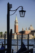 Italy, Venice,Church of San Giorgio Maggiore seen from the waterfront of the Piazzetta San Marco and framed by the silhouette of a lampstand.