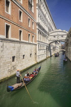 Italy, Venice, Doge's Palace and Bridge of Sighs with gondolas passing.