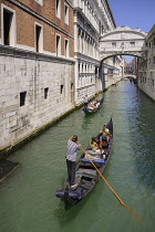 Italy, Venice, Doge's Palace and Bridge of Sighs with gondolas passing.