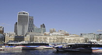 England, London, The view over the River Thames with two Riverboats to the Modern Skyline of City of London with the Walkie Talkie , The Gherkin and Cheesegrater Buildings.