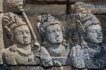Indonesia, Java, Borobudur, Weathered bas-relief of faces of three people.