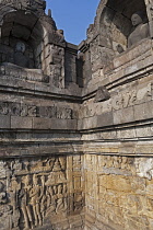 Indonesia, Java, Borobudur, Corner of a passageway, with two adjacent, seated Buddhas in alcoves and stone friezes below them.