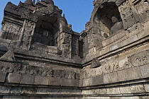 Indonesia, Java, Borobudur, Two seated, granite Buddhas in adjacent corner alcoves; one with a painted white face.