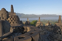 Indonesia, Java, Borobudur, Seated Buddha and small stupas on the top level