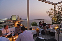 India, Maharashtra, Mumbai, People enjoying a drink at sunset at the rooftop bar of the Intercontinental Hotel on Marine Drive.