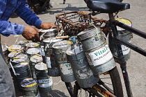 India, Maharashtra, Mumbai, Vital Food's dabbawalla tiffin or lunchbox carrier, loading his bicycle at Churchgate station prior to doing his morning delivery round.