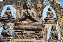 India, Bihar, Bodhgaya, Seated Buddha statues inset in a mini-stupa in the grounds of the Mahabodhi temple.