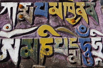 India, Bihar, Bodhgaya, Mani wall, decorated with marigold flowers, in the grounds of the Mahabodhi Temple.