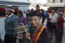 Nepal, Kathmandu, Long exposure showing blur of people walking round the Great Stupa at dusk.