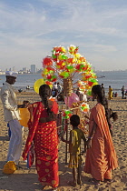 India, Maharashtra, Mumbai, Balloon and toy windmill seller on Chowpatty Beach.