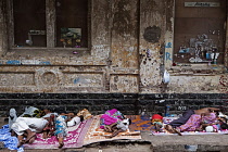 India, Maharashtra, Mumbai, Homeless families asleep on a filthy pavement in Colaba, central Bombay.